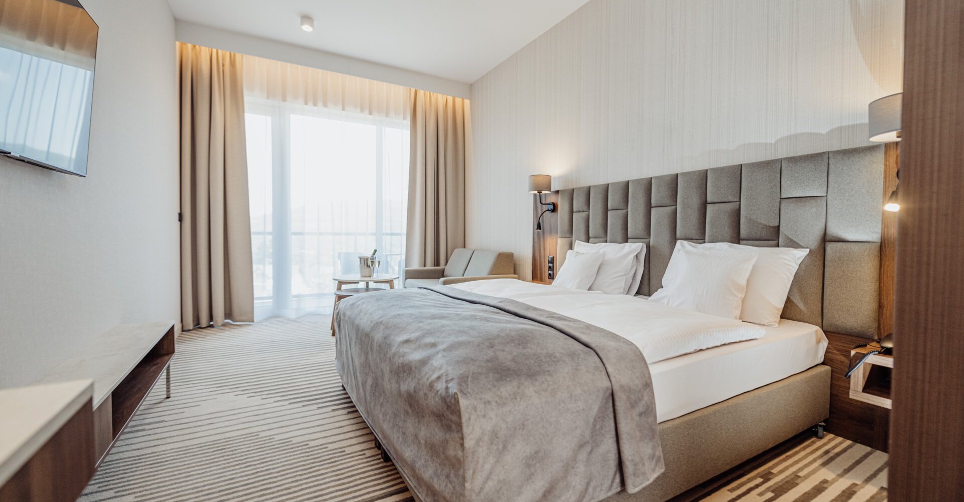 Manželská postel v hotelovém pokoji