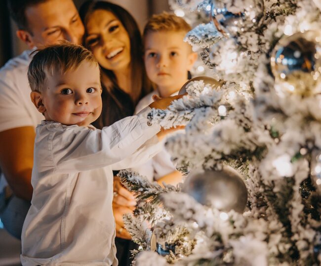 Eltern mit Kindern am Weihnachtsbaum