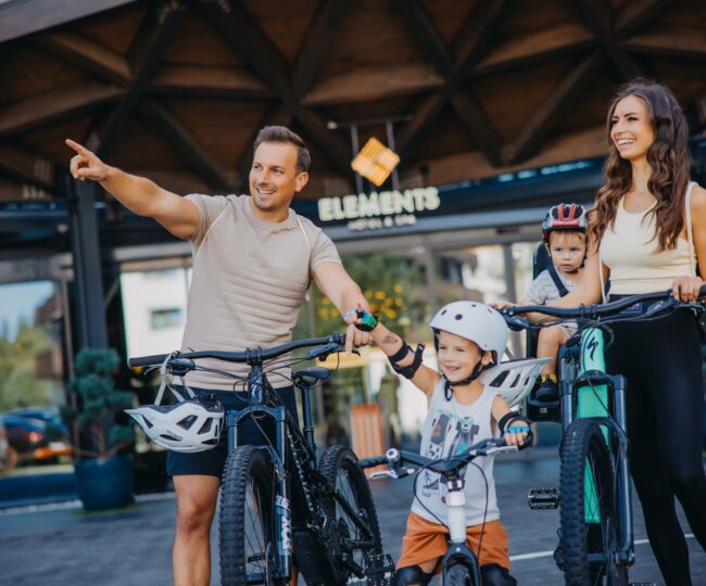 rodzina na rowerach przed hotelem