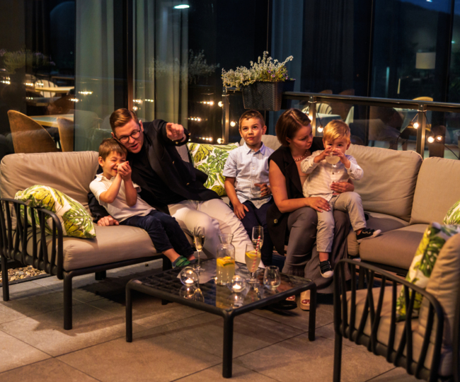 Dzieci z rodzicami na tarasie po zmroku