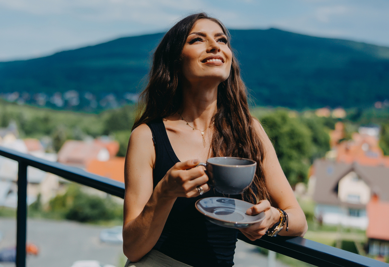 Woman on balcony with cup of coffee