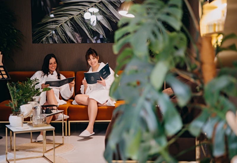 Two women reading spa menu