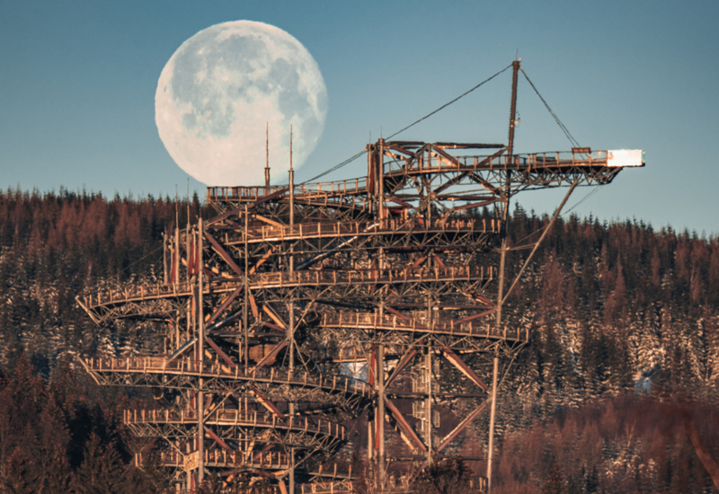 Wieża widokowa na tle gór i księżyca