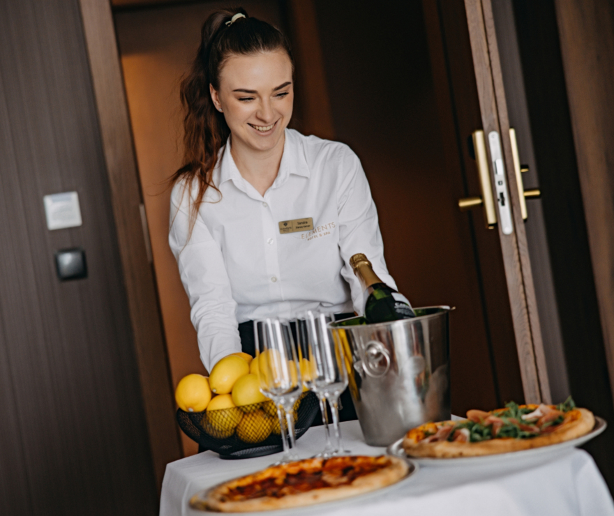 Frau bringt Essen aufs Zimmer