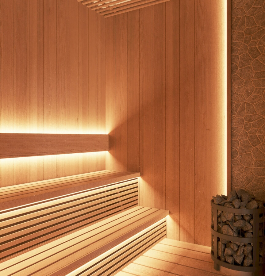Drewniana sauna spa z kilkupoziomowymi ławkami, ciepłym podświetleniem LED i piecem z kamieniami do relaksu.