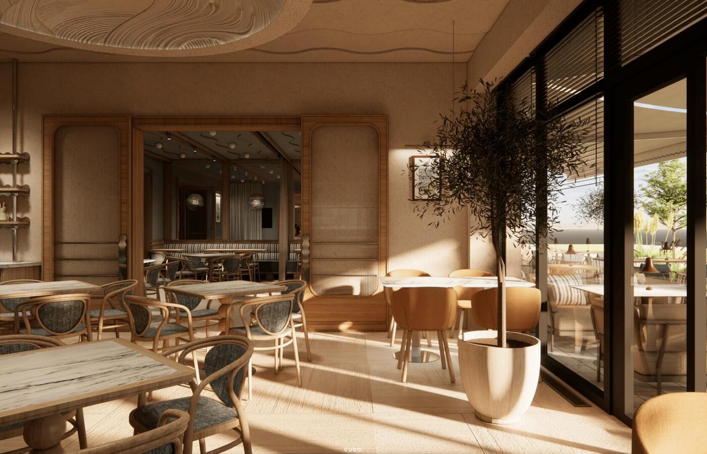 Nasłoneczniona kawiarnia hotelowa z drewnianym wystrojem, rattanowymi krzesłami, stołami jak marmur, donicą z oliwką i tarasem.