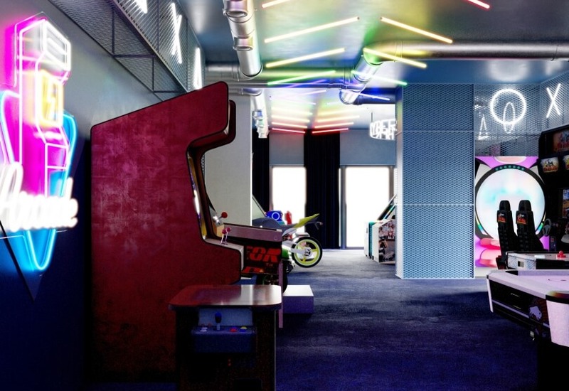 Kolorowa sala gier w hotelu z neonowym sufitem, retro automatami, symulatorami wyścigów i miejscami do zabawy
