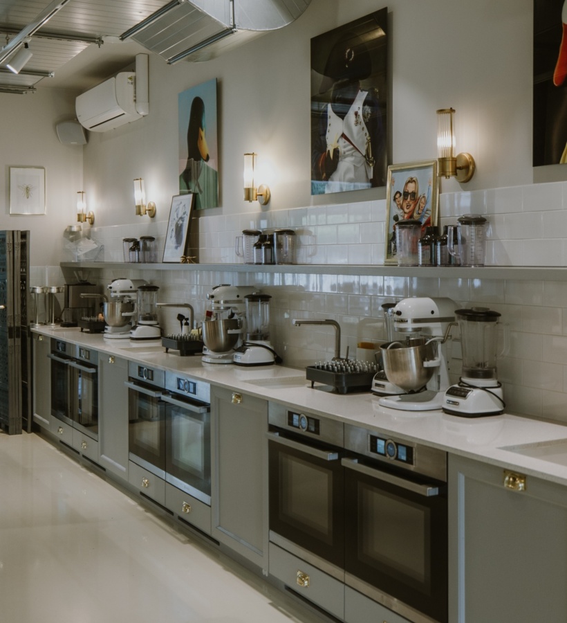 Profesjonalna kuchnia cukiernicza z szeregiem piekarników, mikserów i blenderów na marmurowym blacie