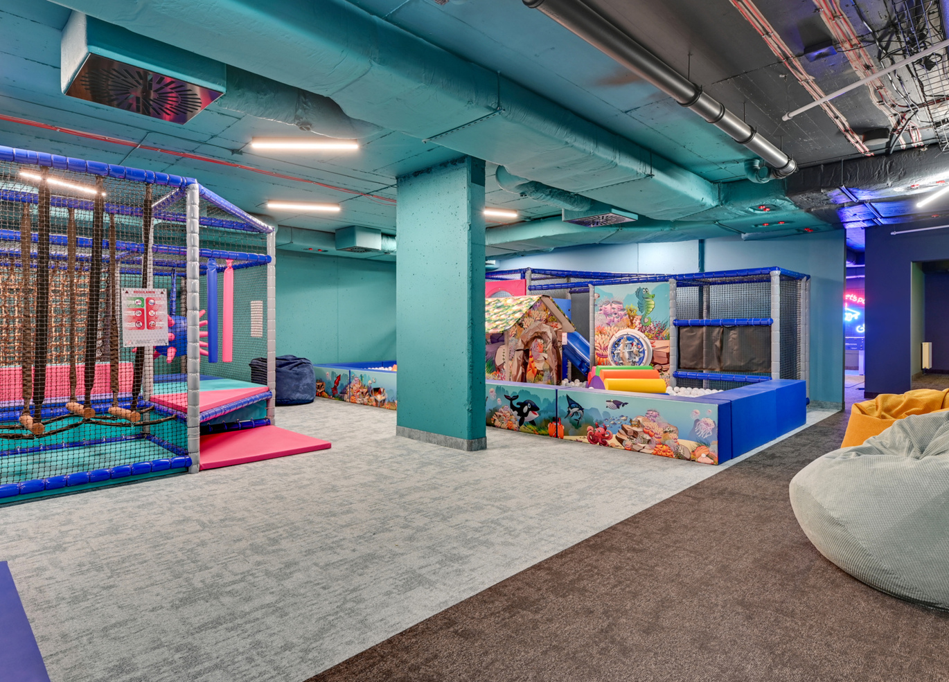 Sala zabaw dla dzieci w hotelu z miękkimi konstrukcjami, basenem z piłkami, torem wspinaczkowym i pufami
