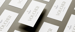 Elegant hotel gift vouchers branded Grano Hotels on a neutral surface, one voucher floating with a soft shadow