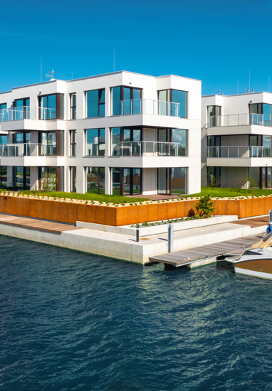 Modern waterfront boutique apartments with glass balconies, floor-to-ceiling windows and private marina with moored yachts