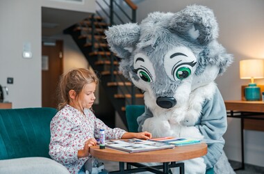Maskotka wilka towarzysząca dziewczynce podczas zajęć plastycznych w Green Mountain w Karpaczu.