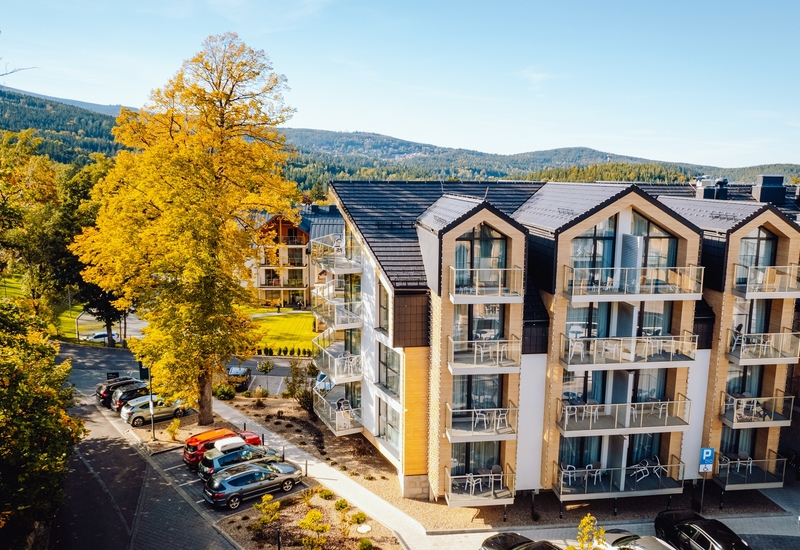 A modern Green Mountain Hotel***** in Karpacz against a mountainous landscape.