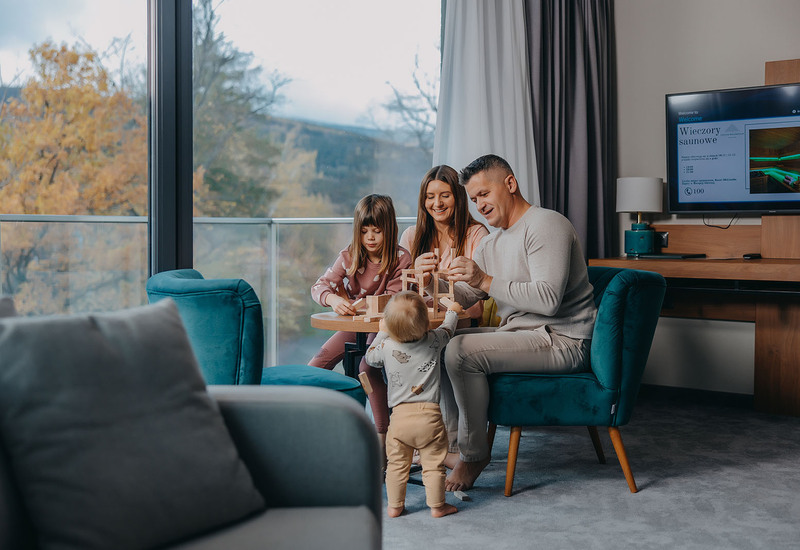 A family with children playing in a hotel room at Green Mountain in Karpacz.