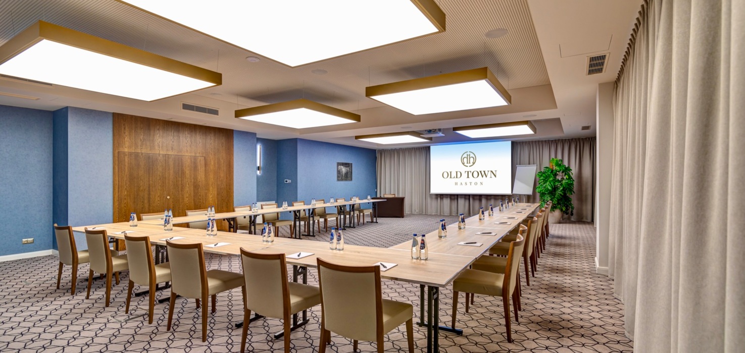 Przestronna sala konferencyjna z nowoczesnym wyposażeniem i rzutnikiem