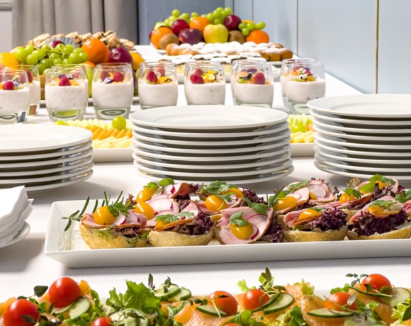 Elegancko nakryty stół z zimnymi przekąskami, sałatkami i wypiekami na konferencji firmowej