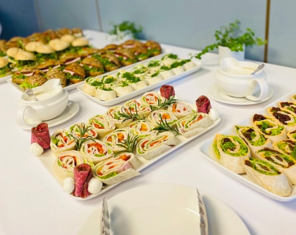 Elegancko nakryty stół z zimnymi przekąskami, sałatkami i wypiekami na konferencji firmowej