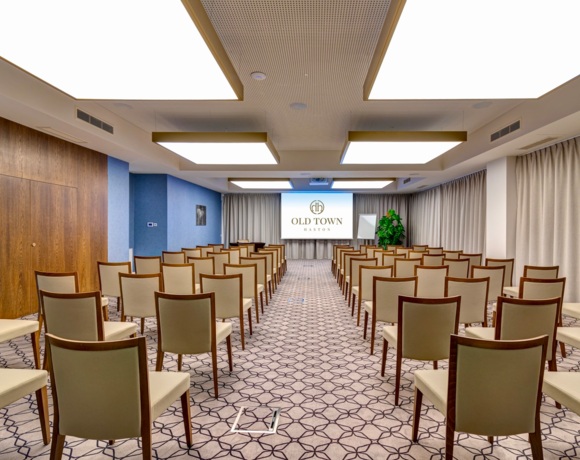 Luksusowa sala konferencyjna z designerskim oświetleniem i nowoczesnym sprzętem audio-wizualnym.