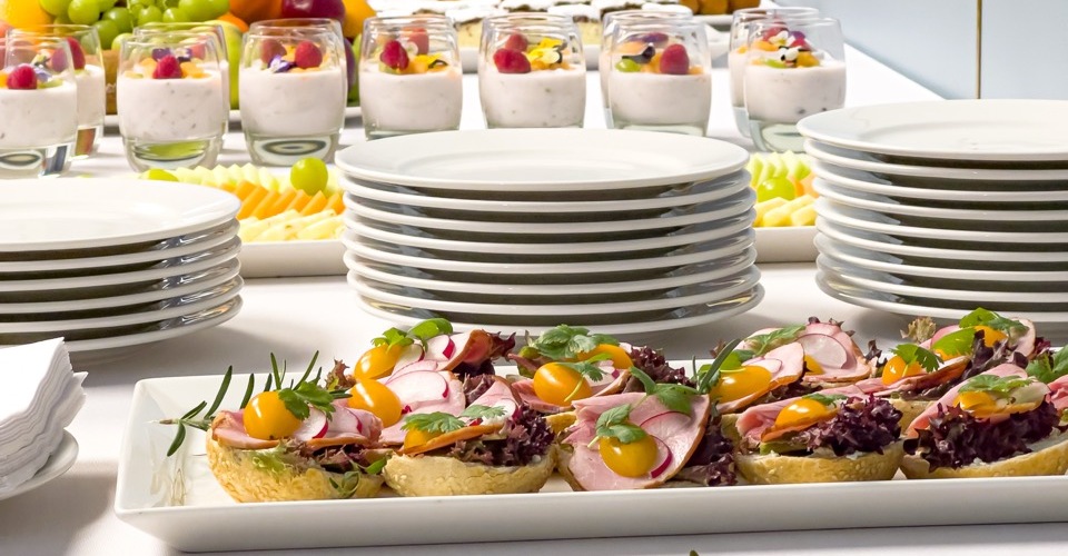 Elegancko nakryty stół z zimnymi przekąskami, sałatkami i wypiekami na konferencji firmowej