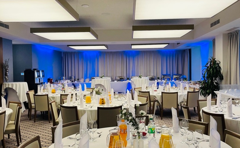 Stylowy wystrój sali restauracyjnej na chrzciny – harmonijny układ stolików i delikatne dekoracje