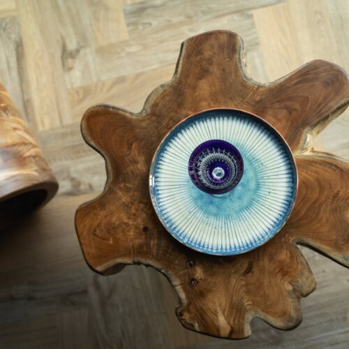 Handgefertigter Tisch aus Naturholz mit dekorativem blauem Keramiktablett auf Holzparkettboden