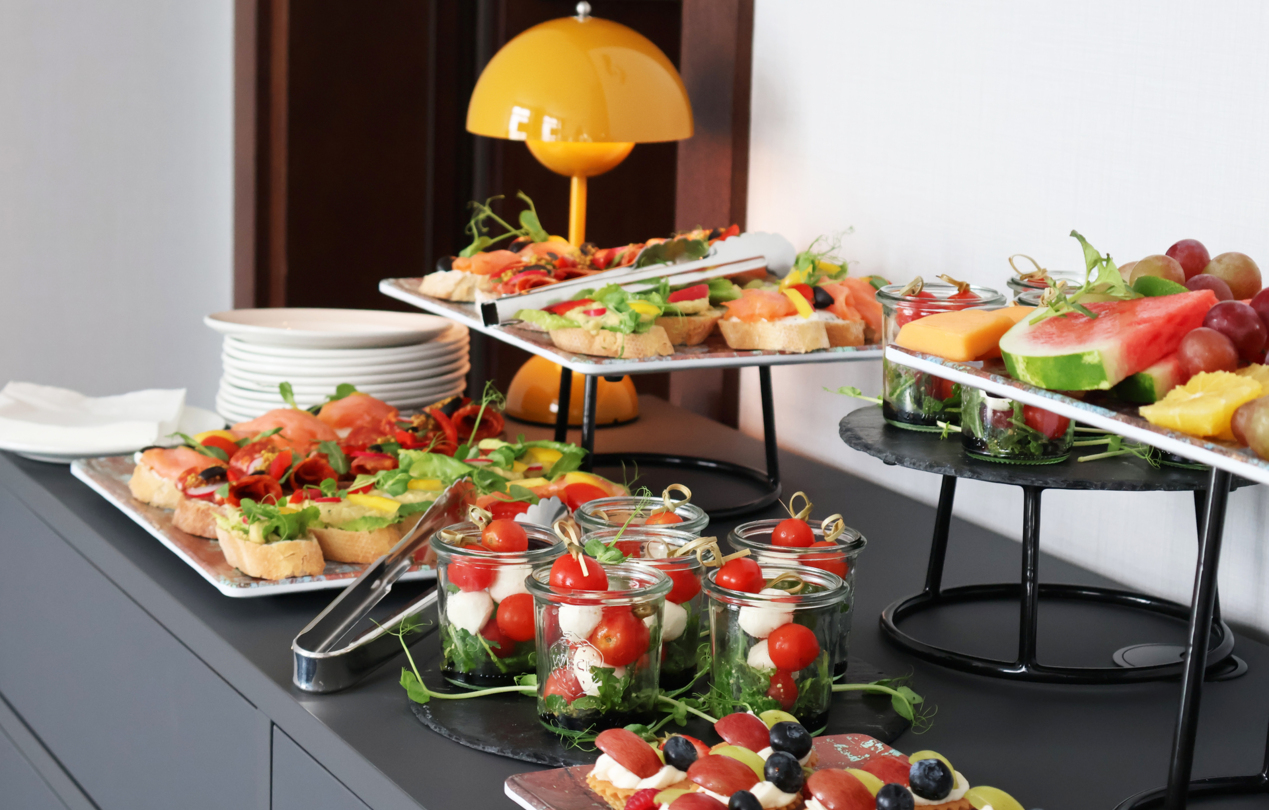 A photo of snacks and mini sandwiches arranged on a countertop in the form of a coffee break