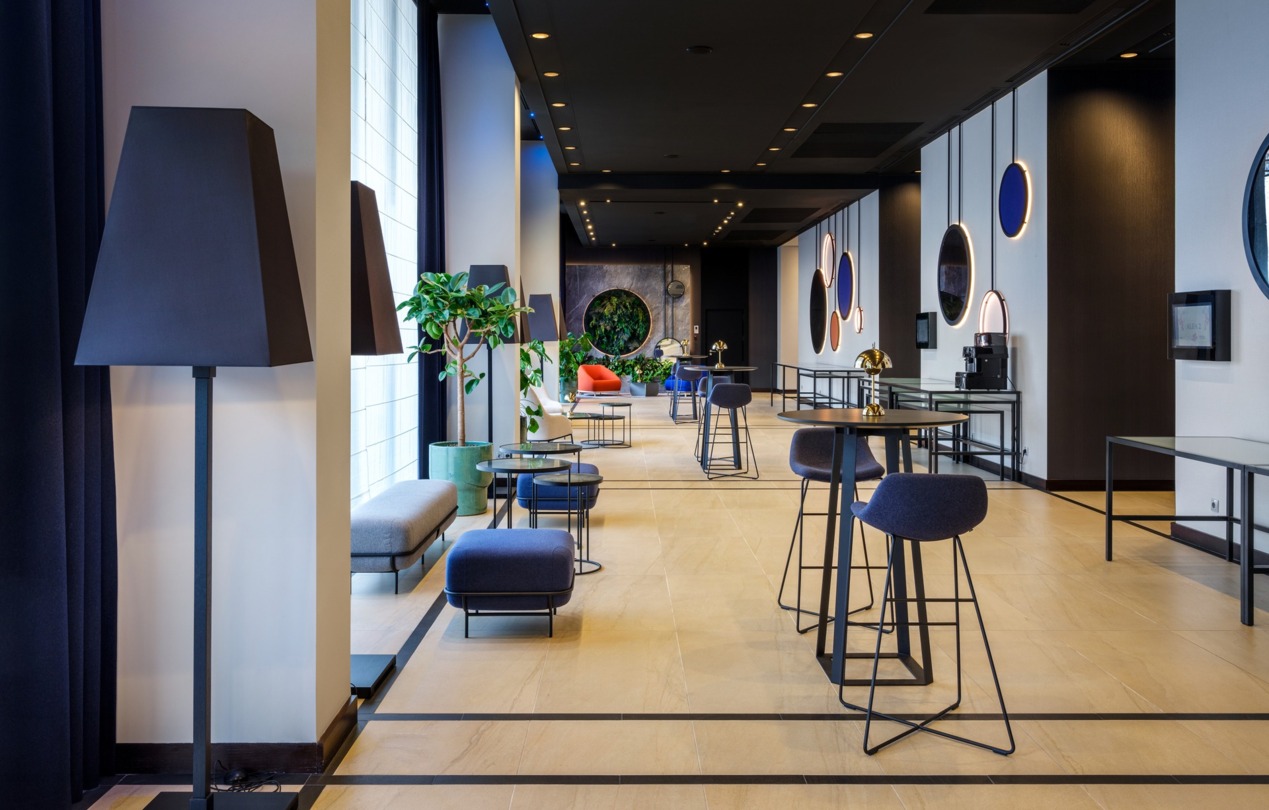 Wnętrze hotelowego lobby z ustawionymi stolikami koktajlowymi