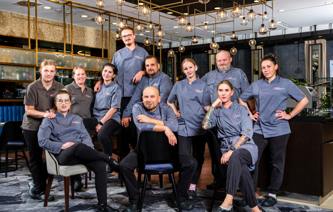 A group photo of the chefs in front of the hotel restaurant interior