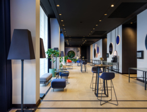 Wnętrze hotelowego lobby z ustawionymi stolikami koktajlowymi