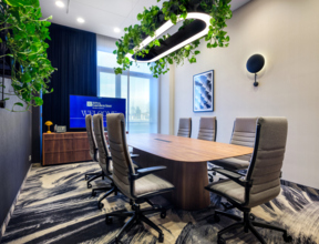 Wnętrze sali konferencyjnej ze stołem prezydialnym i obrotowymi fotelami