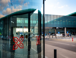 Przeszklone drzwi do hotelu z widokiem na pieszą kładkę łączącą hotel z terminalem lotniska