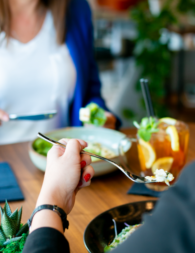 Zdjęcie dwóch kobiet przy stoliku jedzących lunch