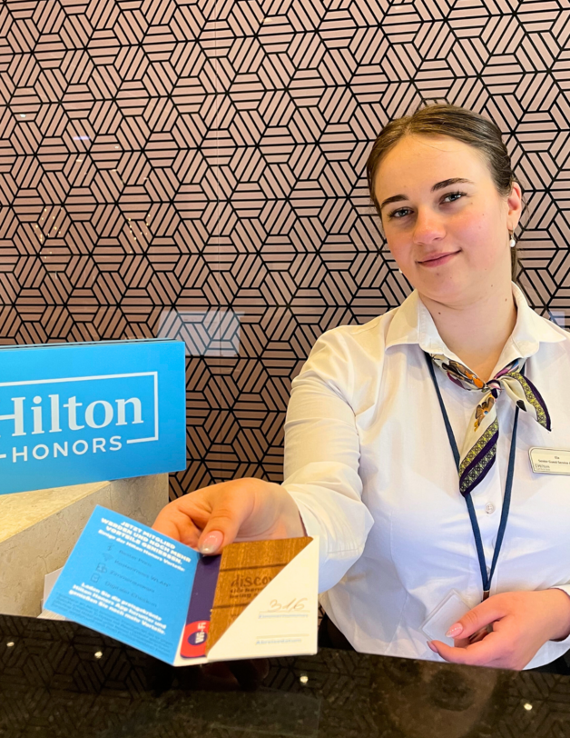 recepcjonistka podająca kartę z kluczem do pokoju