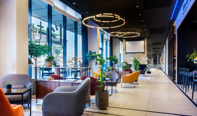 Zdjęcie hotelowego lobby z fotelami i stolikami naprzeciw restauracji