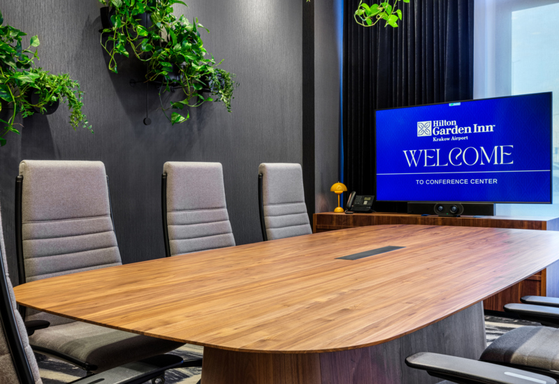 Zdjęcie sali konferencyjnej ze stołem prezydialnym i obrotowymi fotelami