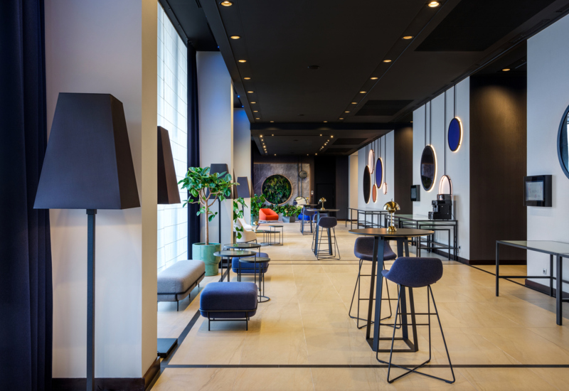 Wnętrze hotelowego lobby z ustawionymi stolikami koktajlowymi