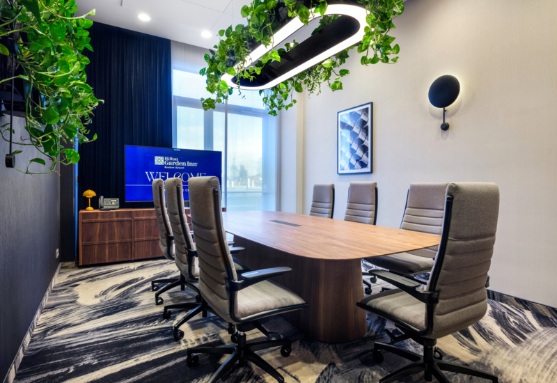 Wnętrze sali konferencyjnej ze stołem prezydialnym i obrotowymi fotelami