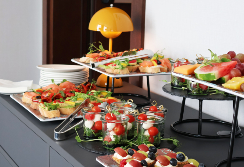 Zdjęcie przekąsek i mini kanapek ustawione na blacie w formie przerwy kawowej