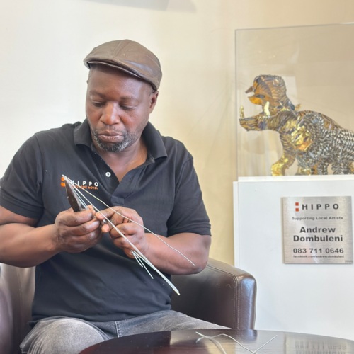 Hotel artisan carefully crafting wire art in a cozy lounge area, showcasing local creativity and cultural decor