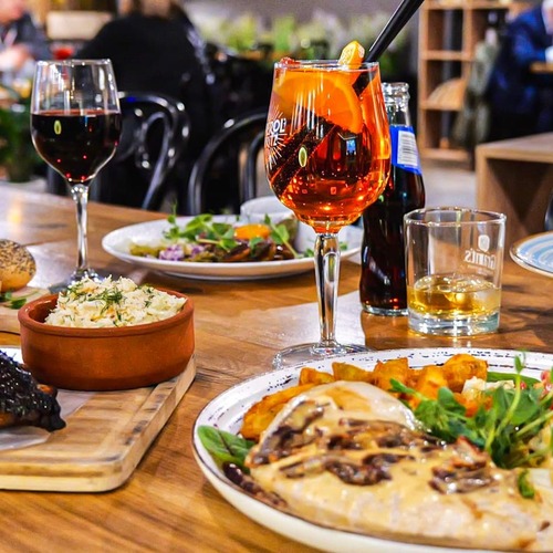 Przytulna restauracja serwująca pyszne, wspólne dania: glazurowane żeberka na frytkach, makaron, sałatkę, pieczywo, surówkę i pomarańczowy koktajl – klimatyczne PragaTu w Warszawie ze świetną ofertą kulinarną blisko stacji metra Dworzec Wileński.