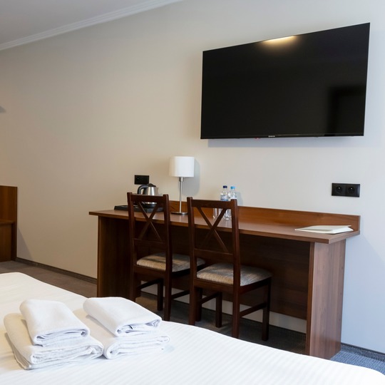 Desk and TV in the room at Hit Hotel