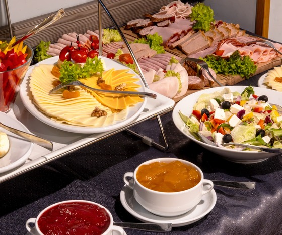 Varied breakfast buffet with a selection of cheeses, cold cuts, fresh vegetables and preserves – proven accommodation in Warsaw near the National Stadium.