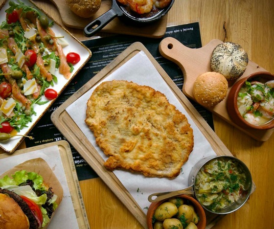 Dania kuchni europejskiej i przekąski serwowane na drewnianym stole w restauracji hotelowej