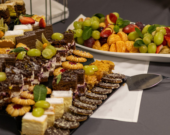 Różnorodne mini ciasta, ciasteczka i świeże owoce (winogrona, truskawki, mandarynki) na bufecie deserowym hotelu