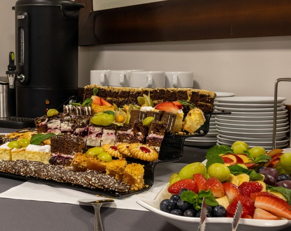 Dessertbuffet mit verschiedenen Kuchen, Keksen, Obst und frischem Kaffee – attraktives Hotel in Warschau für ein gelungenes Wochenende in der Hauptstadt.
