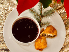 Tradiční polský červený boršč v bílé misce s kroketem a větvičkou smrku na svátečním stole