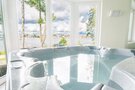 Jacuzzi z widokiem na jezioro przez duże okna