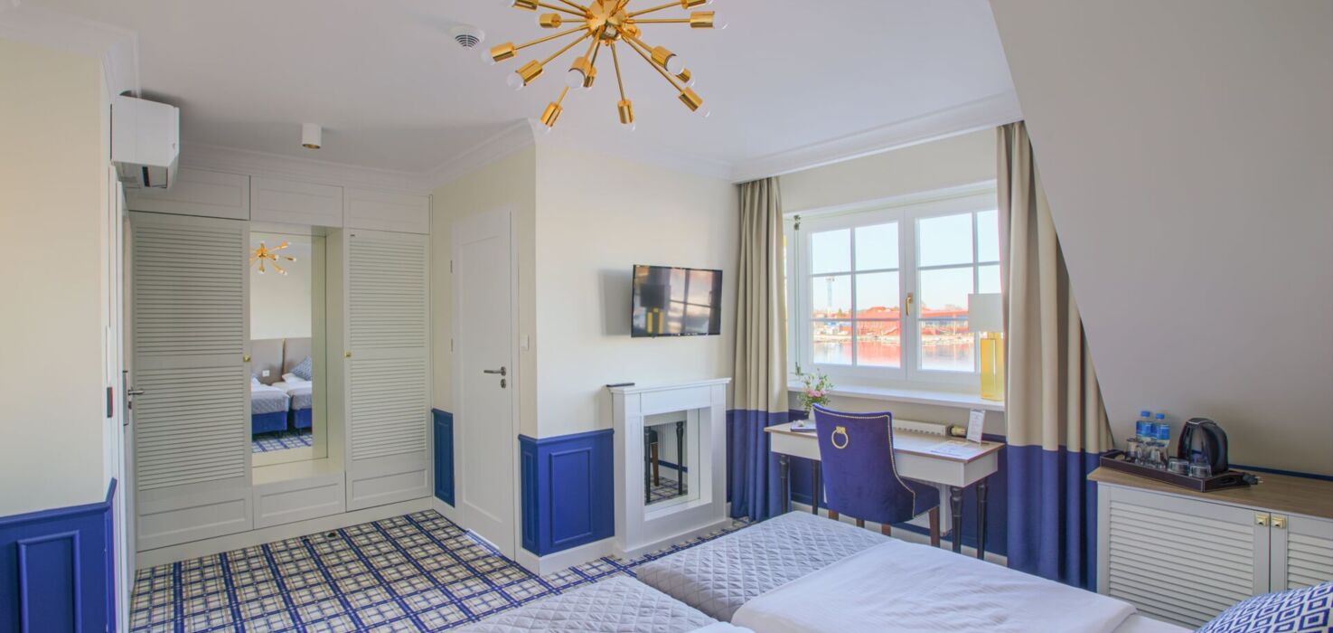 Nowoczesny pokój hotelowy z dwoma łóżkami, biurkiem i dużym oknem