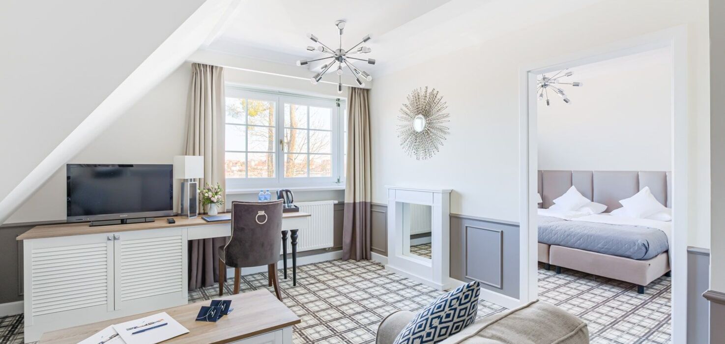 Salon apartamentu hotelowego z widokiem na sypialnię