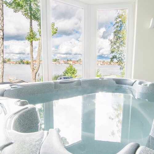 Jacuzzi z widokiem na jezioro przez duże okna